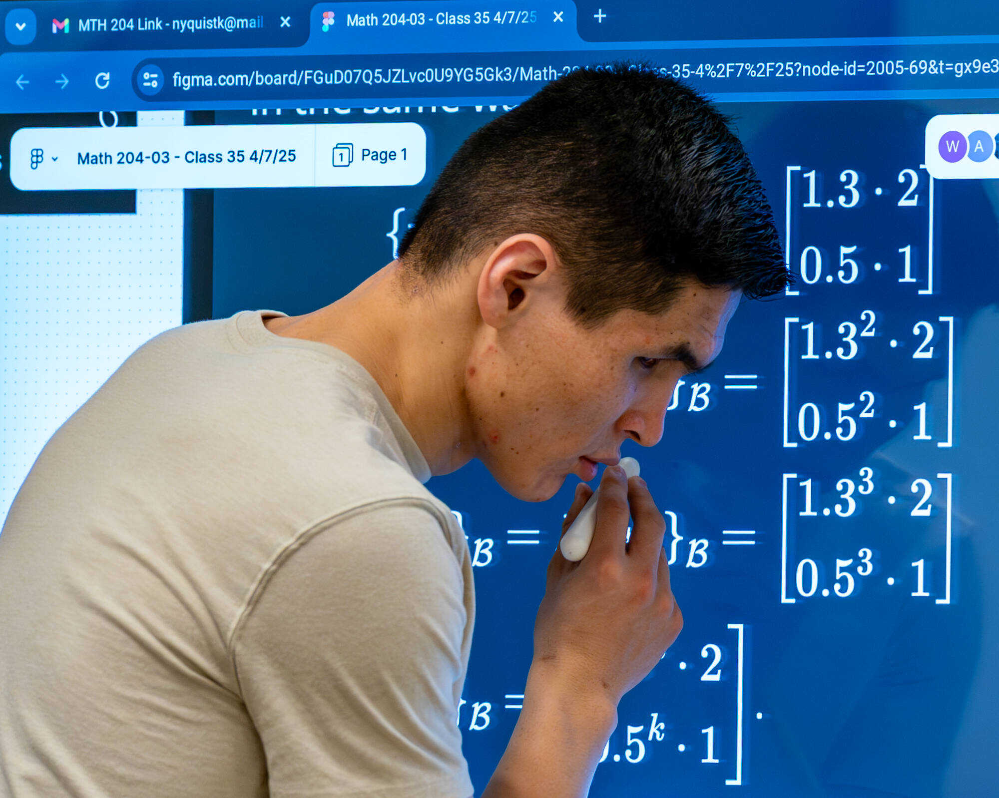 A student stands in front of a large screen displaying magnified math notation.